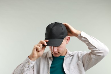 Photo of Man in stylish baseball cap on light grey background. Mockup for design