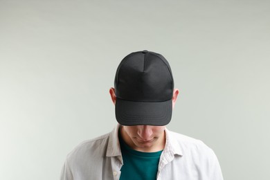 Photo of Man in stylish baseball cap on light grey background. Mockup for design