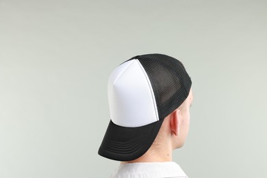 Photo of Man in stylish baseball cap on light grey background, back view. Mockup for design