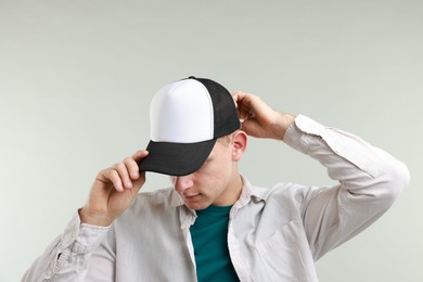 Photo of Man in stylish baseball cap on light grey background. Mockup for design