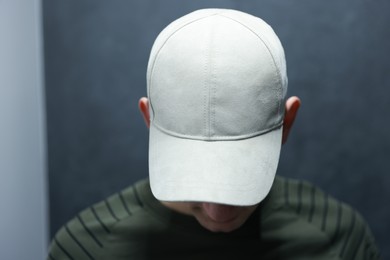 Man in stylish baseball cap on blurred background. Mockup for design