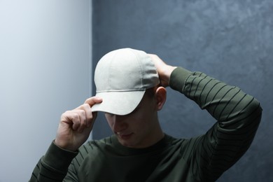 Photo of Man in stylish baseball cap on blurred background. Mockup for design