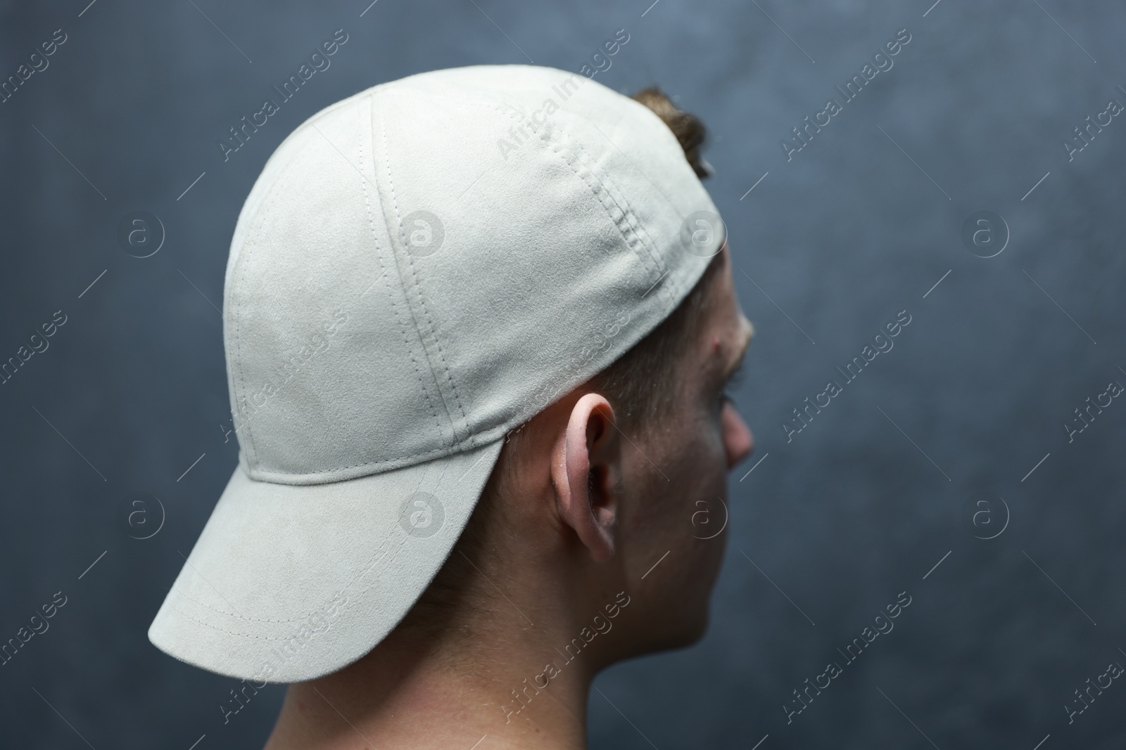 Photo of Man in stylish baseball cap on blurred grey background, closeup. Mockup for design