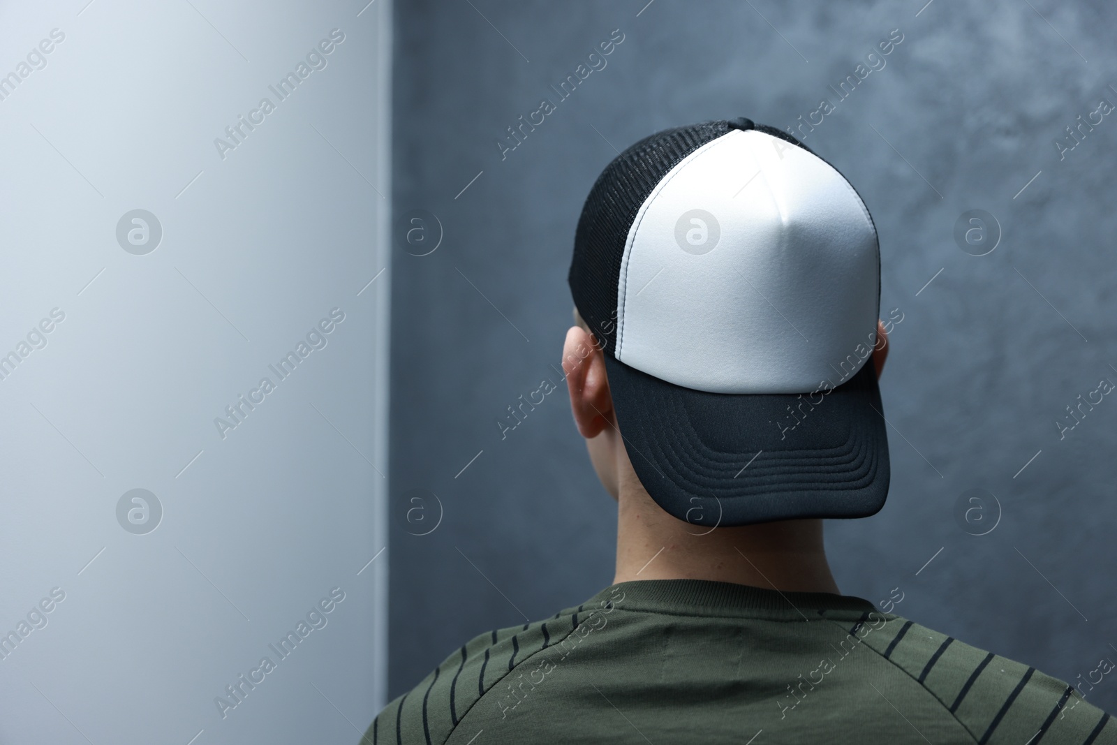 Photo of Man in stylish baseball cap on blurred background, back view. Mockup for design