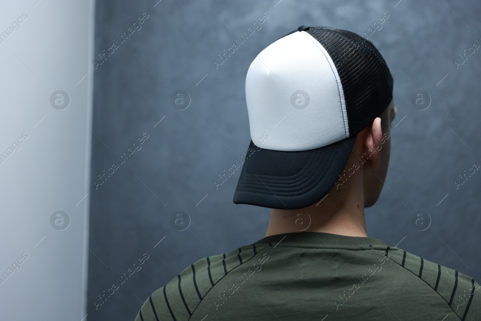 Photo of Man in stylish baseball cap on blurred background, back view. Mockup for design