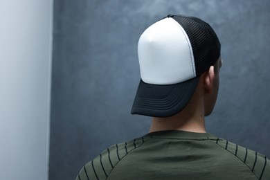 Photo of Man in stylish baseball cap on blurred background, back view. Mockup for design