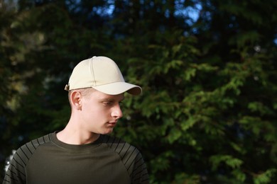 Photo of Man in stylish baseball cap outdoors. Mockup for design