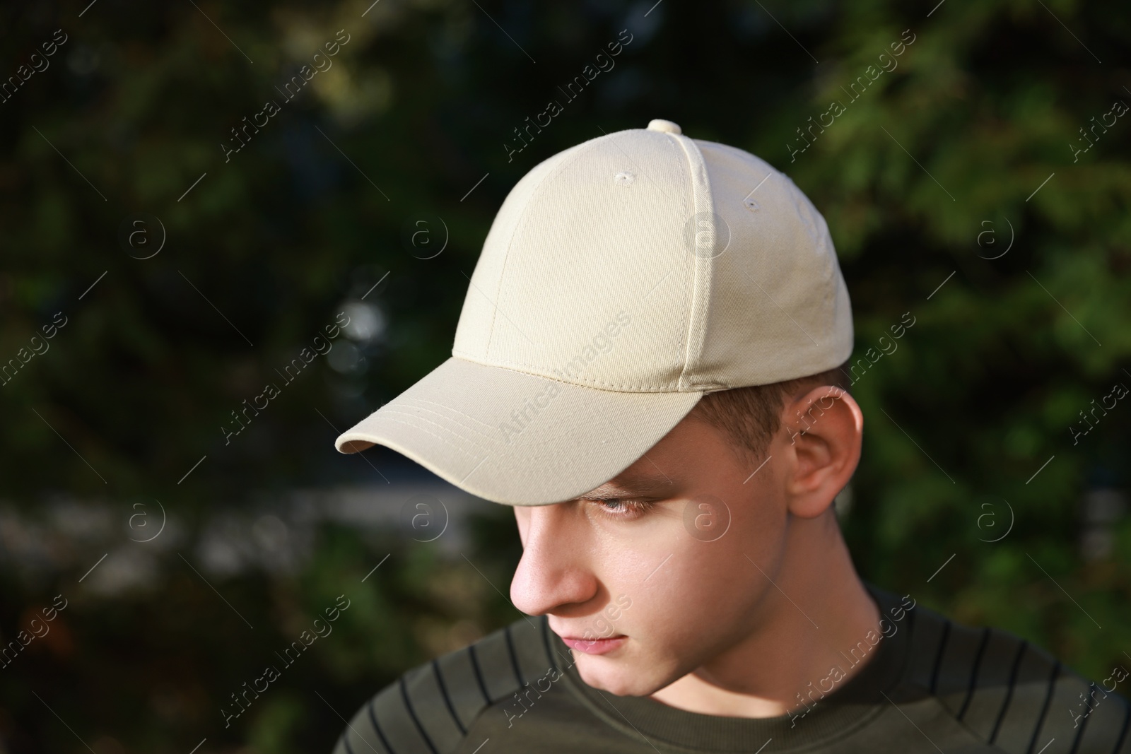 Photo of Man in stylish baseball cap outdoors. Mockup for design