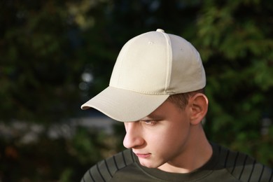 Photo of Man in stylish baseball cap outdoors. Mockup for design