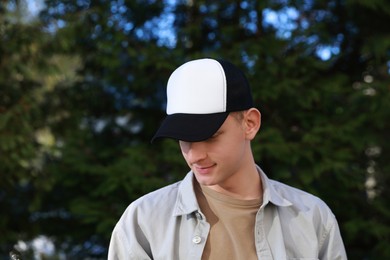 Photo of Man in stylish baseball cap outdoors. Mockup for design