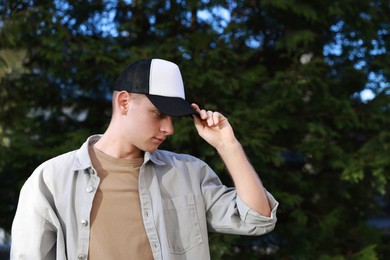 Photo of Man in stylish baseball cap outdoors. Mockup for design