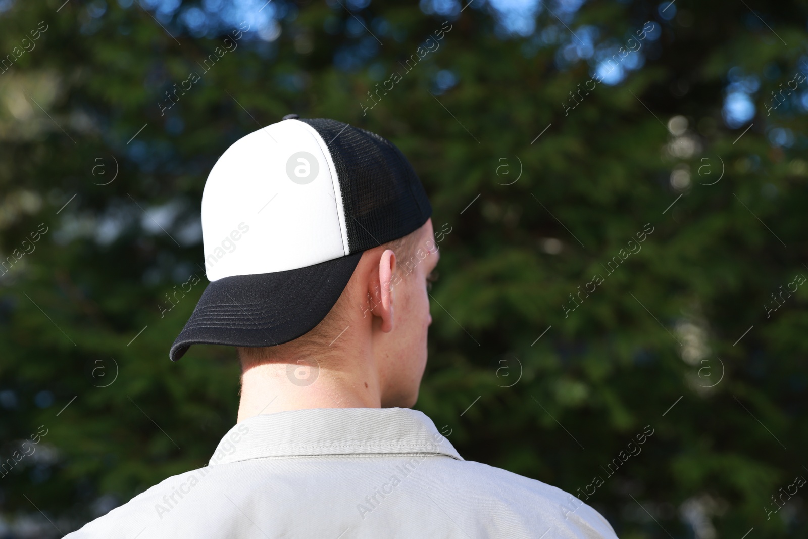 Photo of Man in stylish baseball cap outdoors, back view. Mockup for design