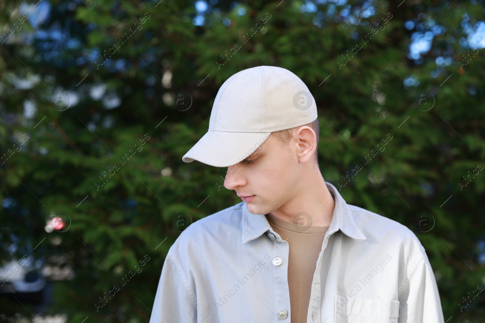 Photo of Man in stylish baseball cap outdoors. Mockup for design