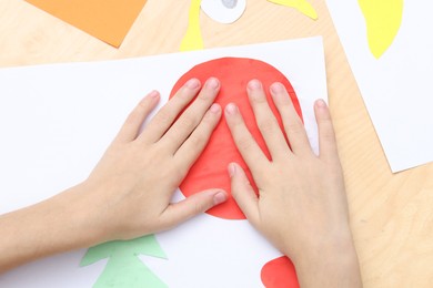 Girl making art project at table indoors, above view