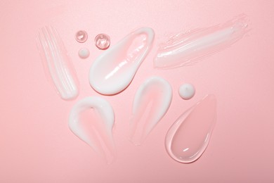 Photo of Cream and gel samples on pink background, top view