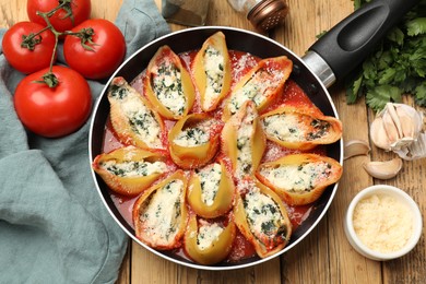 Photo of Delicious shell pasta stuffed with ricotta and spinach served on wooden table, flat lay