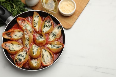 Photo of Delicious shell pasta stuffed with ricotta and spinach served on white marble table, flat lay. Space for text