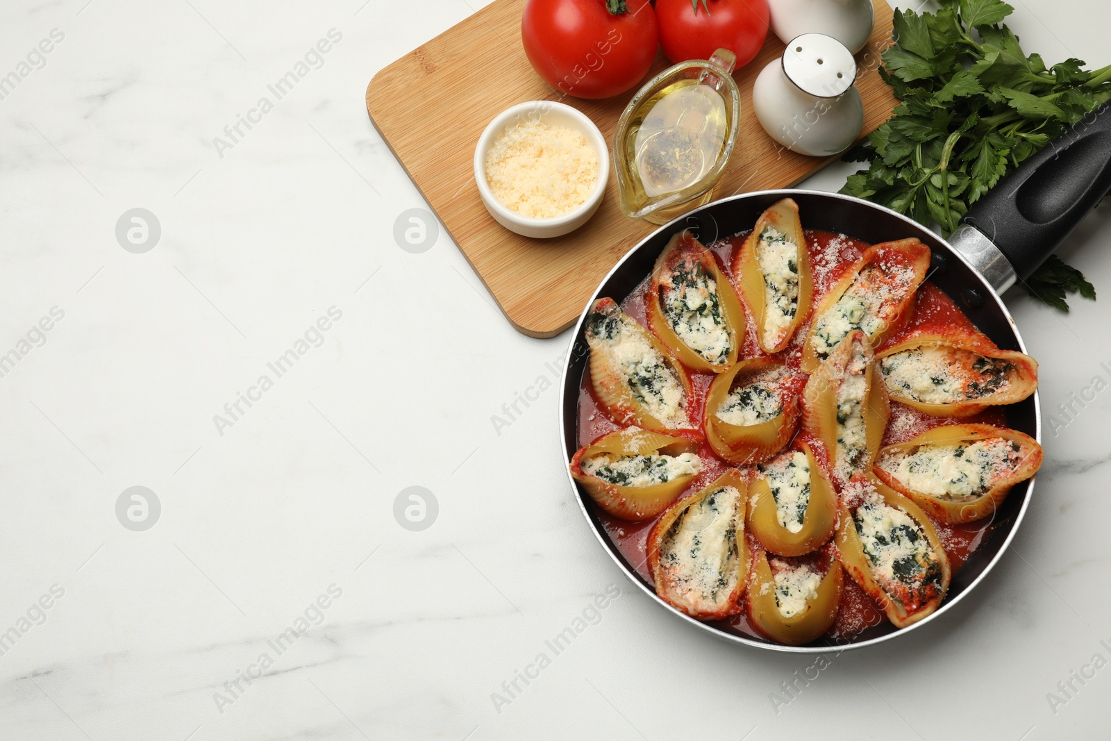 Photo of Delicious shell pasta stuffed with ricotta and spinach served on white marble table, flat lay. Space for text