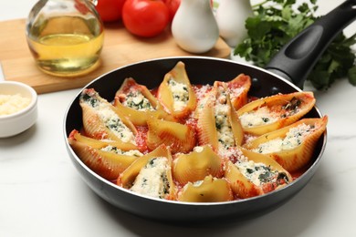 Photo of Delicious shell pasta stuffed with ricotta and spinach served on white table, closeup