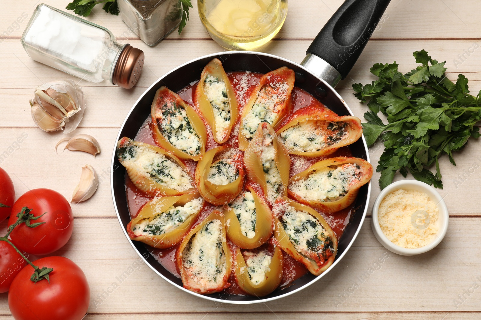 Photo of Delicious shell pasta stuffed with ricotta and spinach served on white wooden table, flat lay