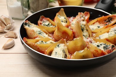 Photo of Delicious shell pasta stuffed with ricotta and spinach served on white wooden table, closeup