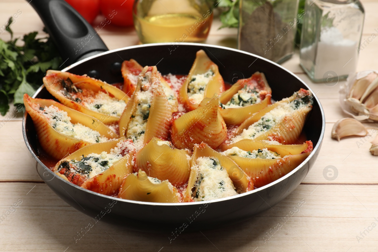 Photo of Delicious shell pasta stuffed with ricotta and spinach served on white wooden table, closeup