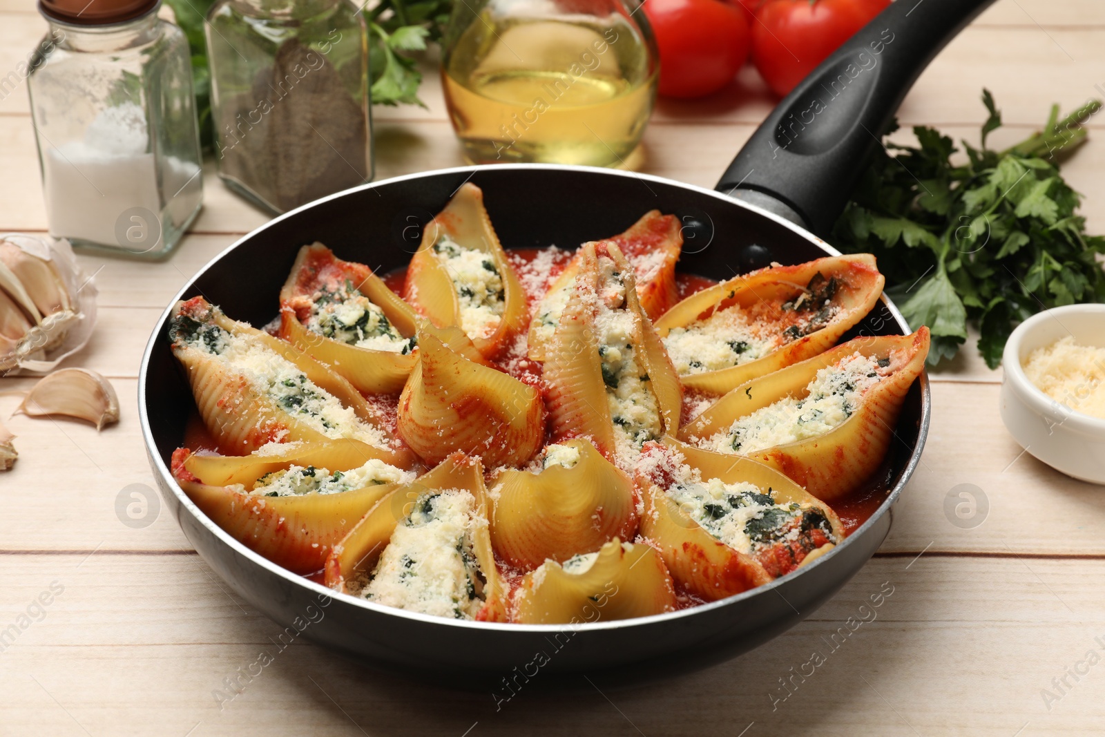 Photo of Delicious shell pasta stuffed with ricotta and spinach served on white wooden table, closeup