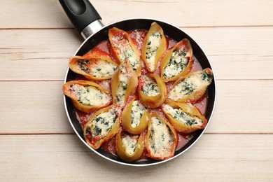 Photo of Delicious shell pasta stuffed with ricotta and spinach on white wooden table, top view