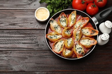 Photo of Delicious shell pasta stuffed with ricotta and spinach served on wooden table, flat lay. Space for text