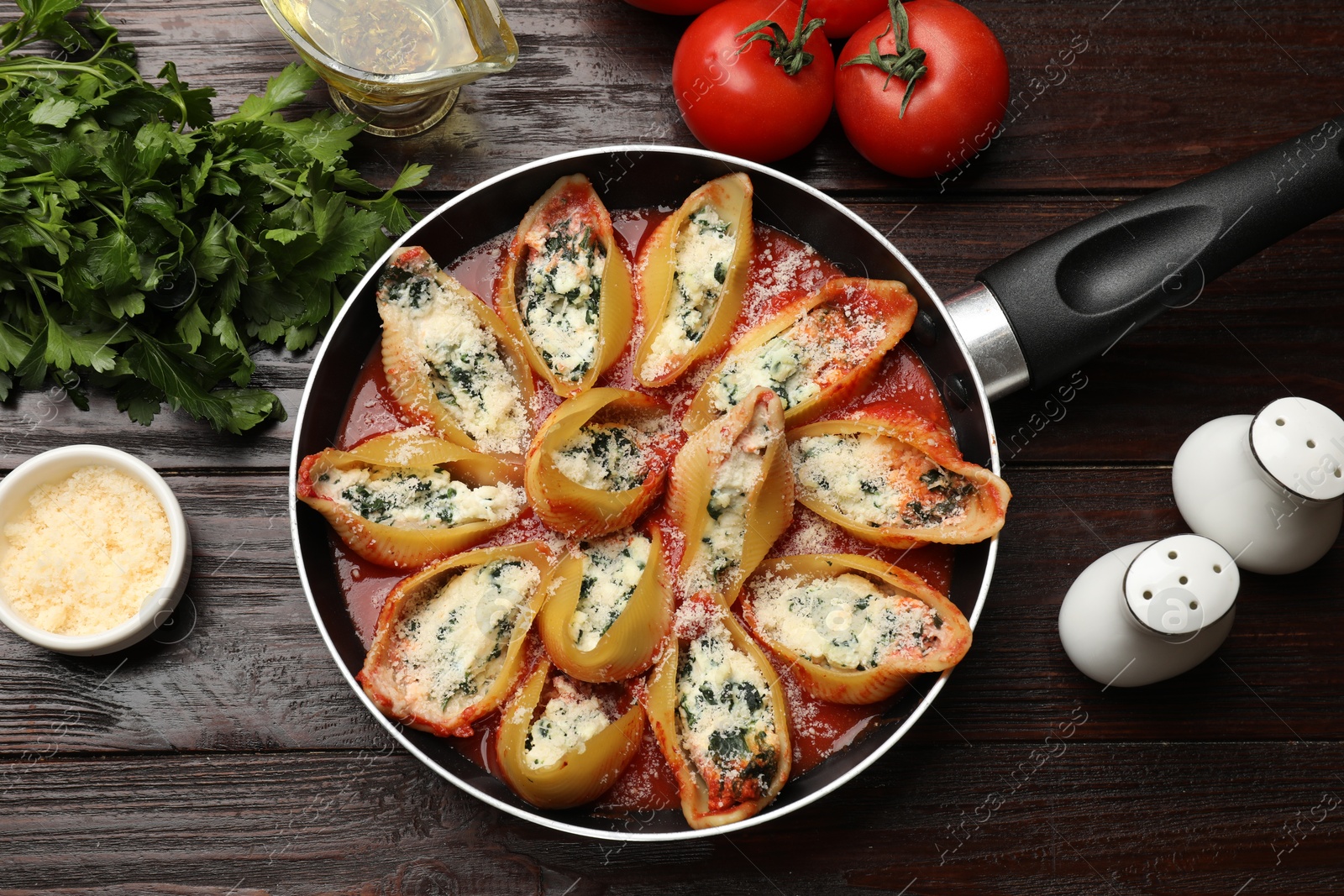 Photo of Delicious shell pasta stuffed with ricotta and spinach served on wooden table, flat lay