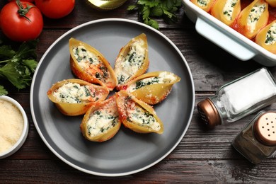 Photo of Delicious shell pasta stuffed with ricotta and spinach served on wooden table, flat lay