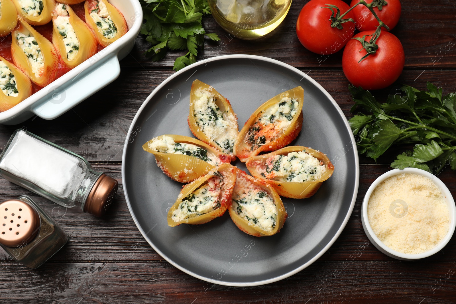 Photo of Delicious shell pasta stuffed with ricotta and spinach served on wooden table, flat lay