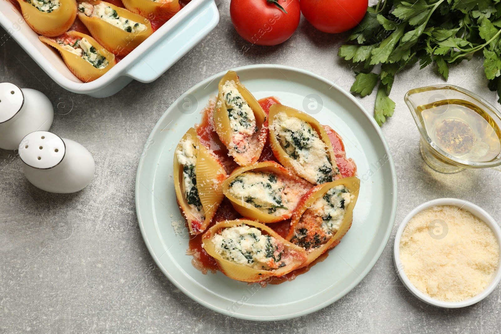 Photo of Delicious shell pasta stuffed with ricotta and spinach served on light grey table, flat lay