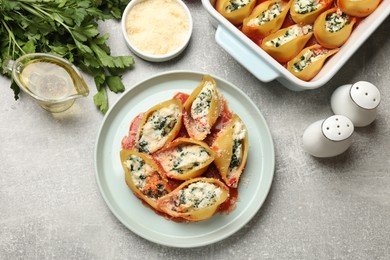 Photo of Delicious shell pasta stuffed with ricotta and spinach served on light grey table, flat lay