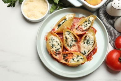 Photo of Delicious shell pasta stuffed with ricotta and spinach served on white table, flat lay