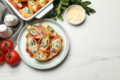 Photo of Delicious shell pasta stuffed with ricotta and spinach served on white table, flat lay. Space for text