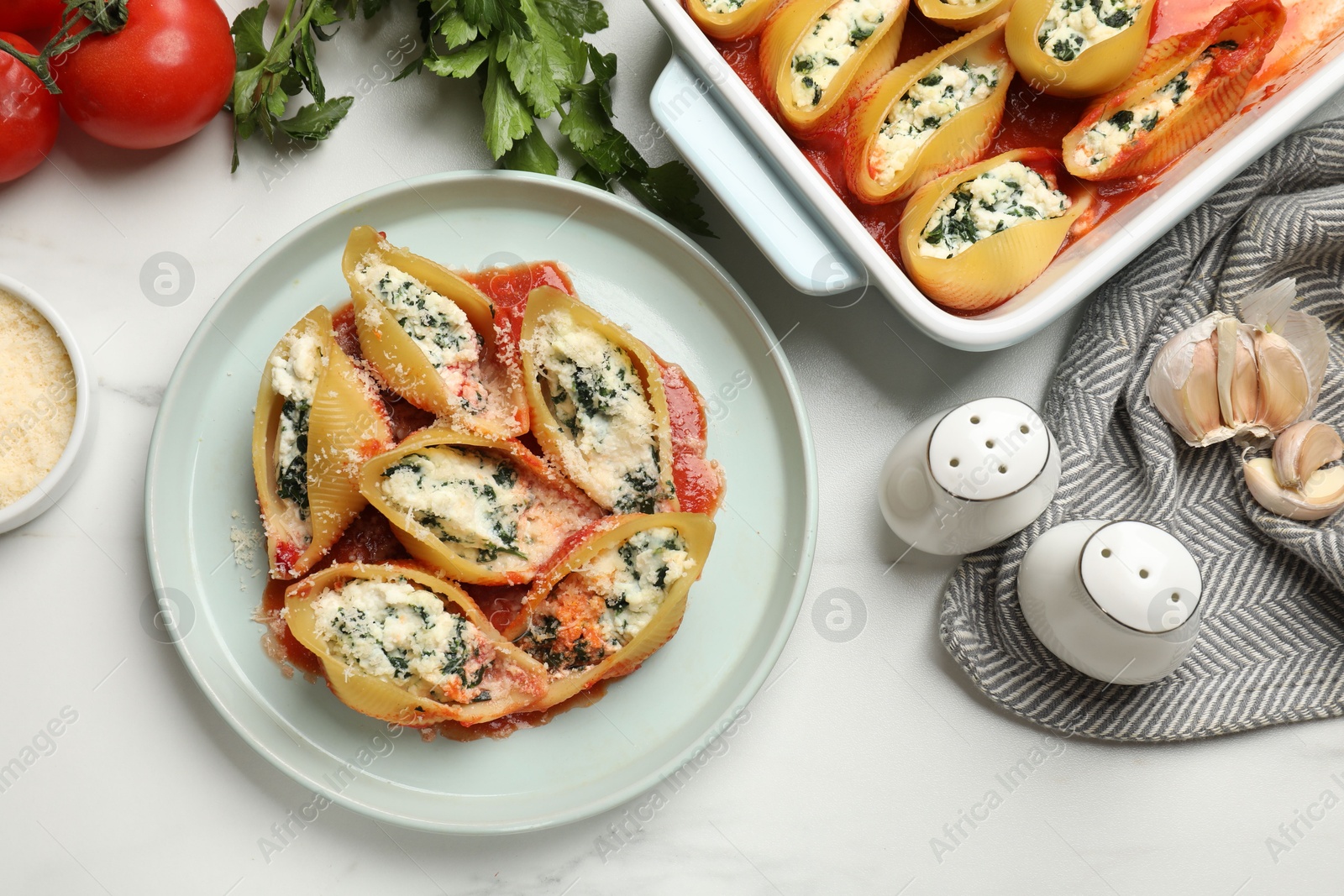 Photo of Delicious shell pasta stuffed with ricotta and spinach served on white table, flat lay