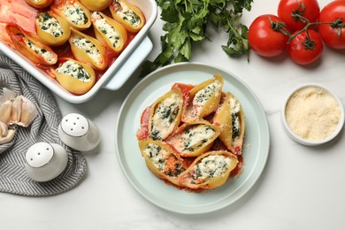 Photo of Delicious shell pasta stuffed with ricotta and spinach served on white table, flat lay