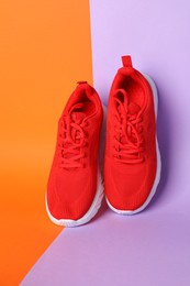 Photo of Pair of stylish red sneakers on color background