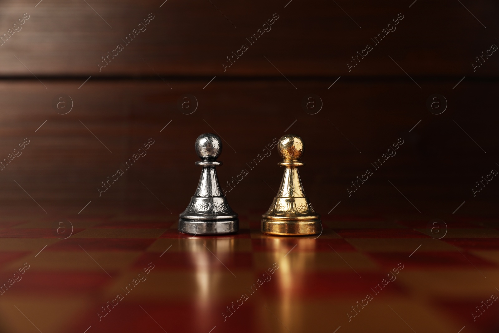 Photo of Golden and silver pawns in middle of chessboard. Competition concept