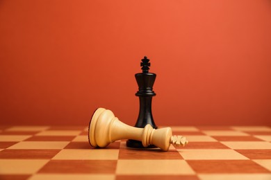 Photo of Black chess king near fallen white one in middle of chessboard. Competition concept