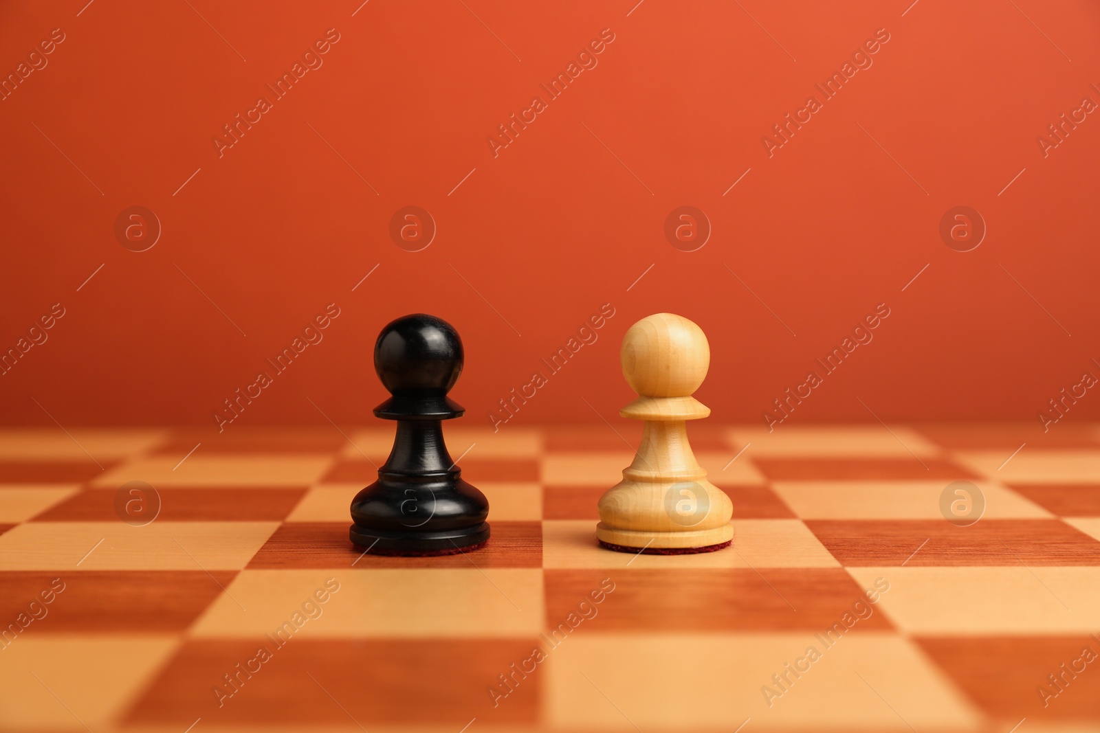 Photo of Black and white pawns in middle of chessboard. Competition concept