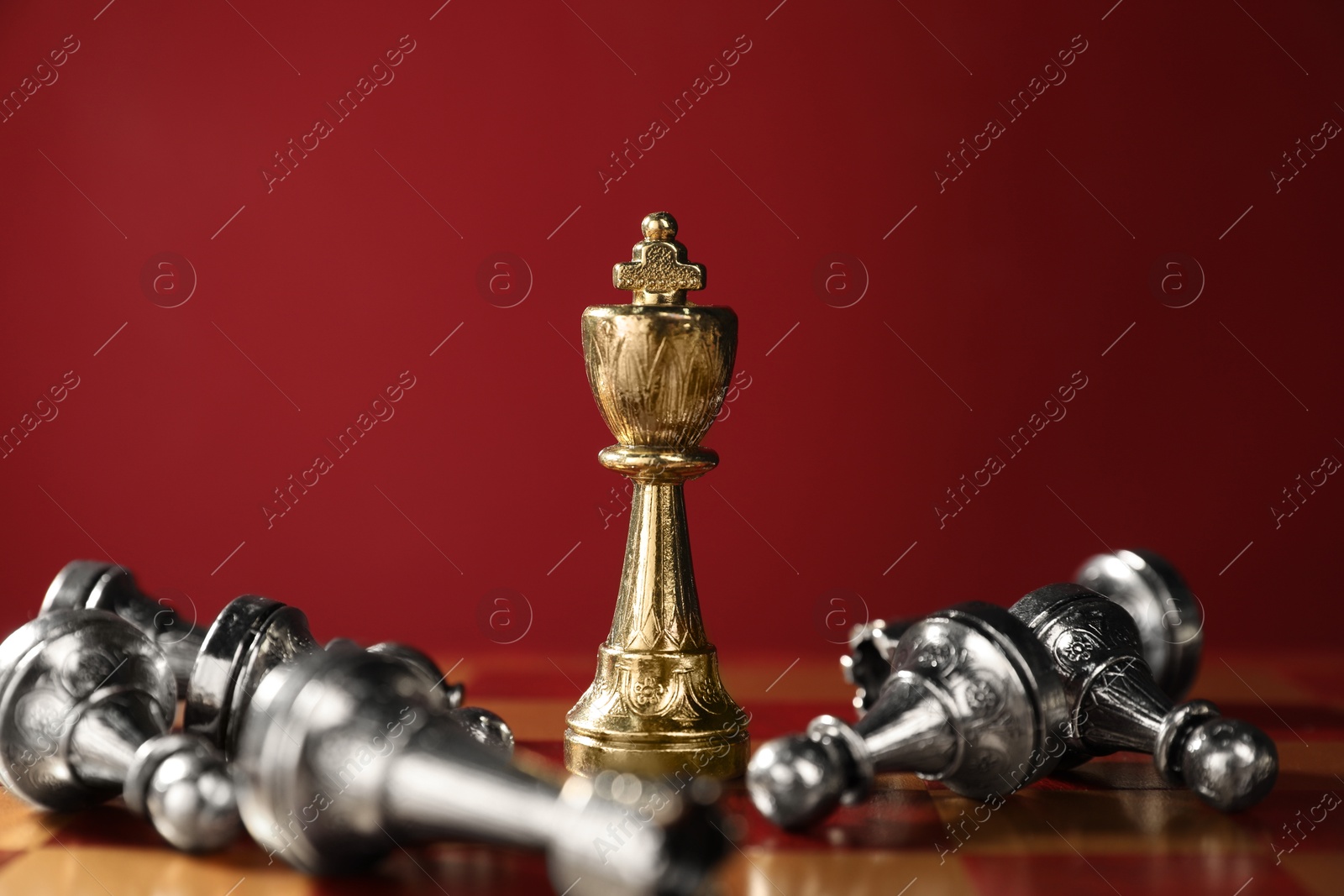 Photo of Golden chess king among fallen silver ones on chessboard, closeup. Competition concept