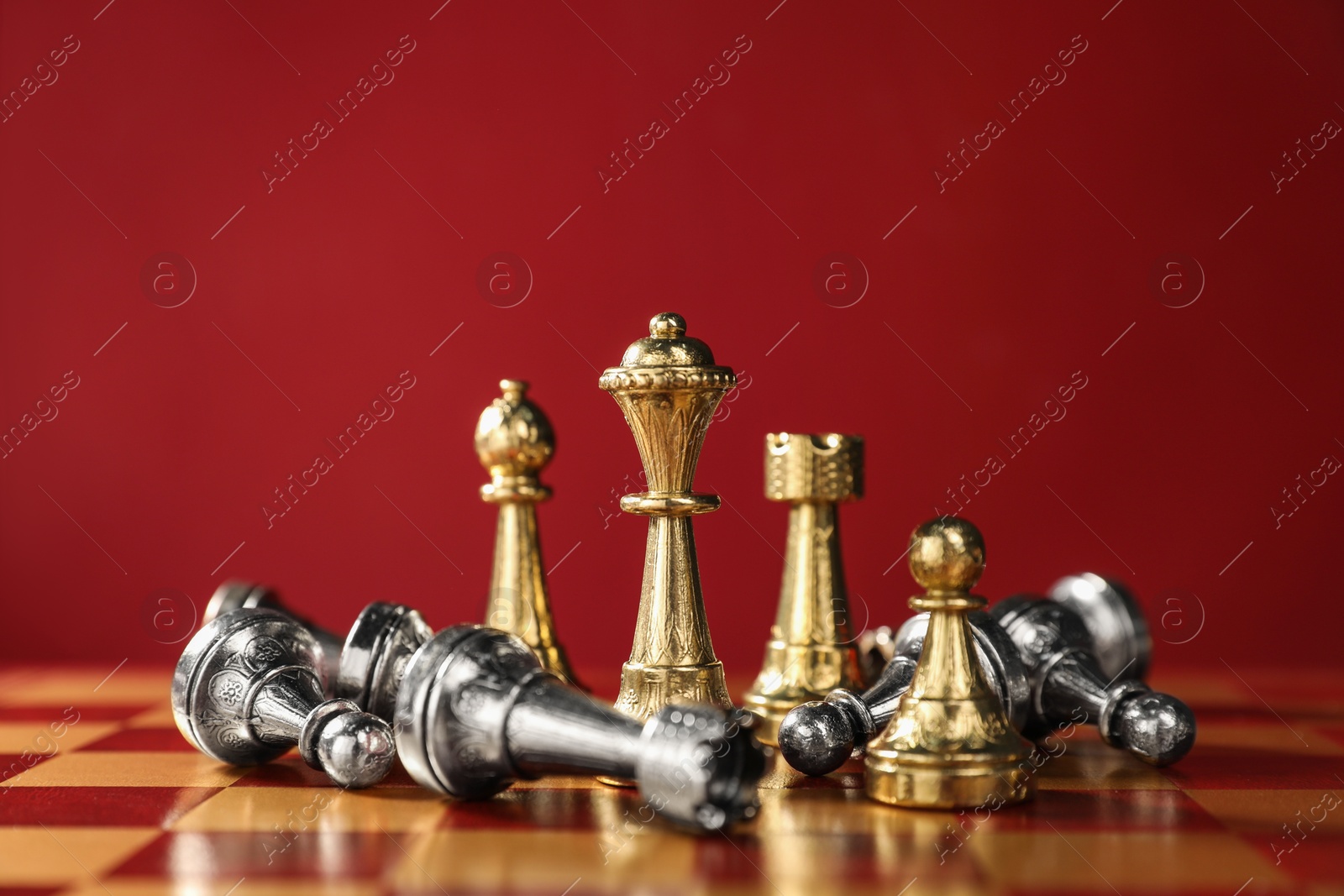 Photo of Golden chess pieces among other fallen silver ones on chessboard. Competition concept