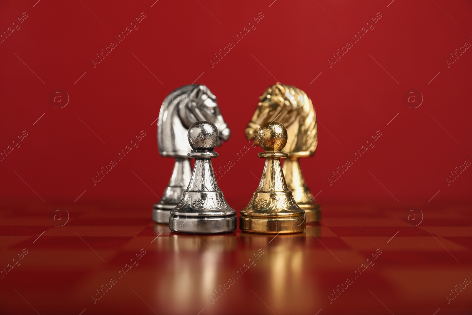 Photo of Golden and silver chess knights in middle of chessboard. Competition concept