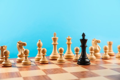 Photo of Black king in front of other white chess pieces on chessboard. Competition concept