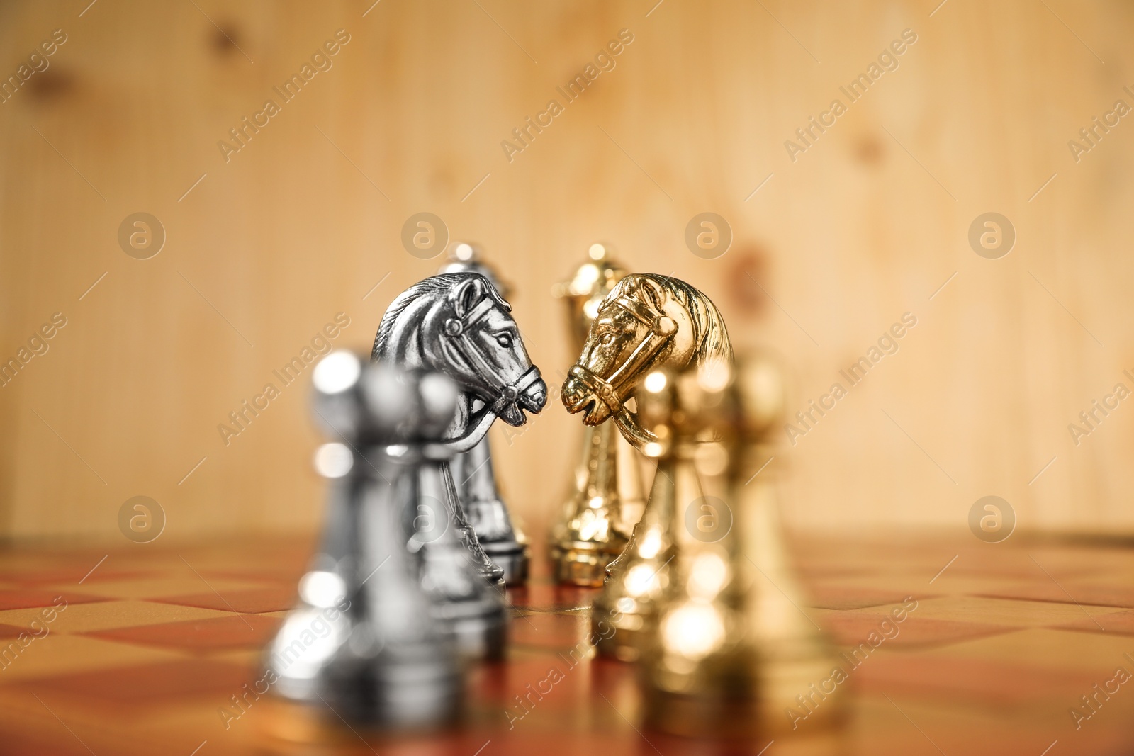 Photo of Golden and silver chess pieces on chessboard, closeup. Competition concept