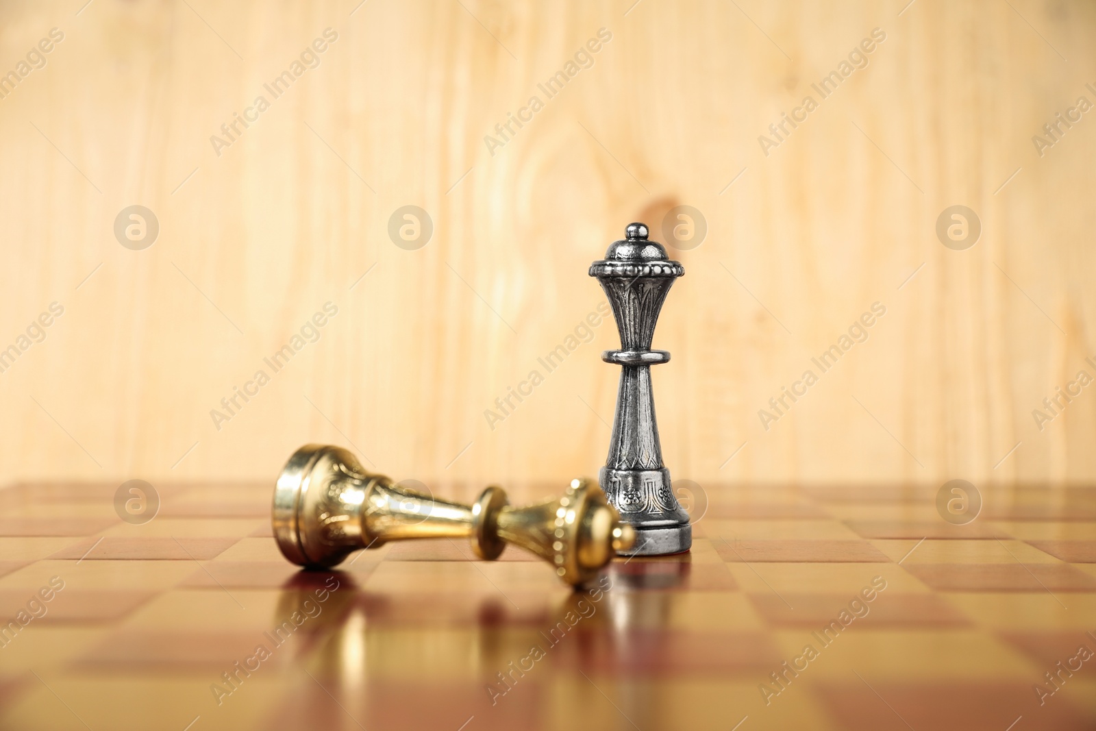 Photo of Silver chess queen near fallen golden one on chessboard. Competition concept