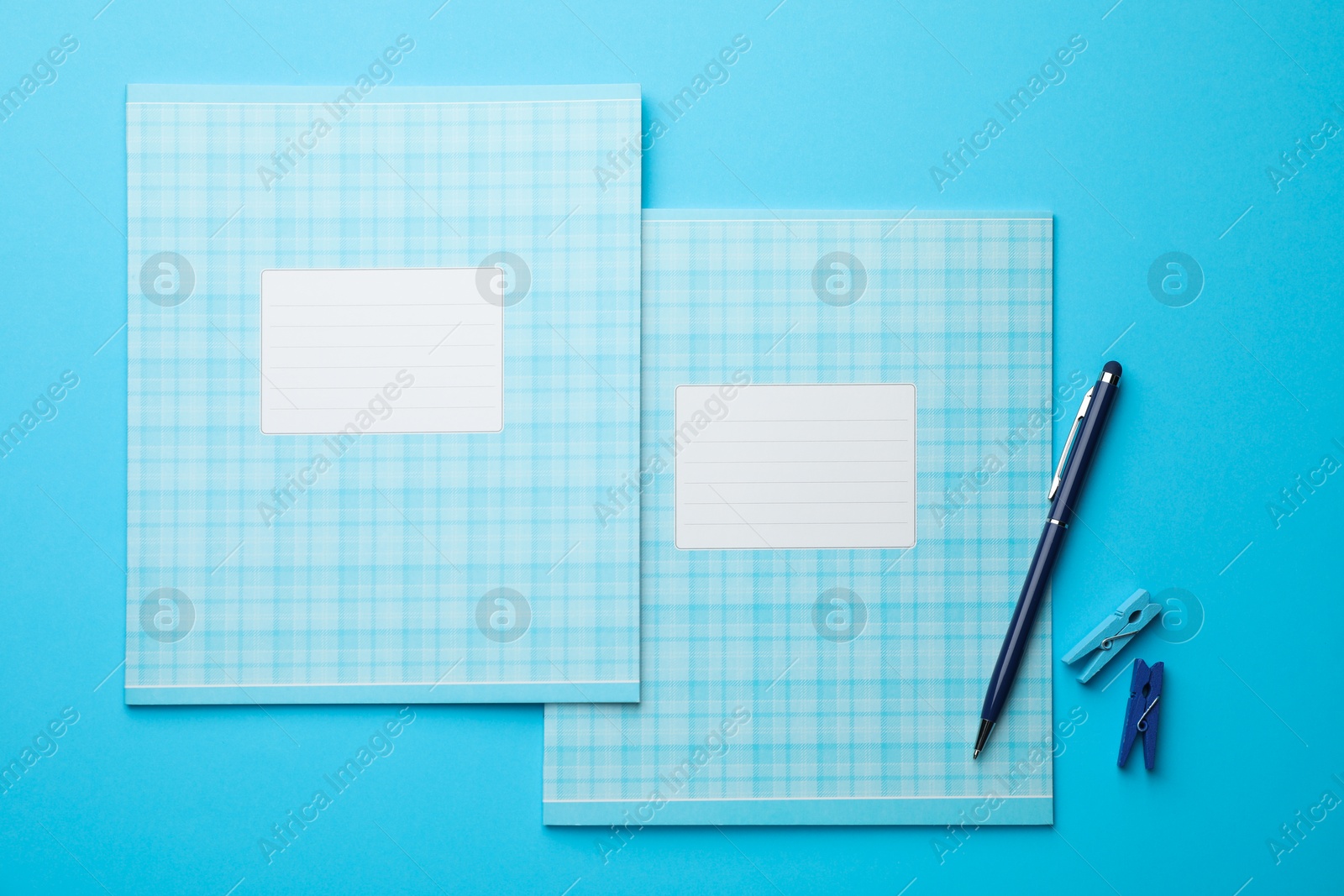 Photo of Flat lay composition with copybooks and pen on light blue background