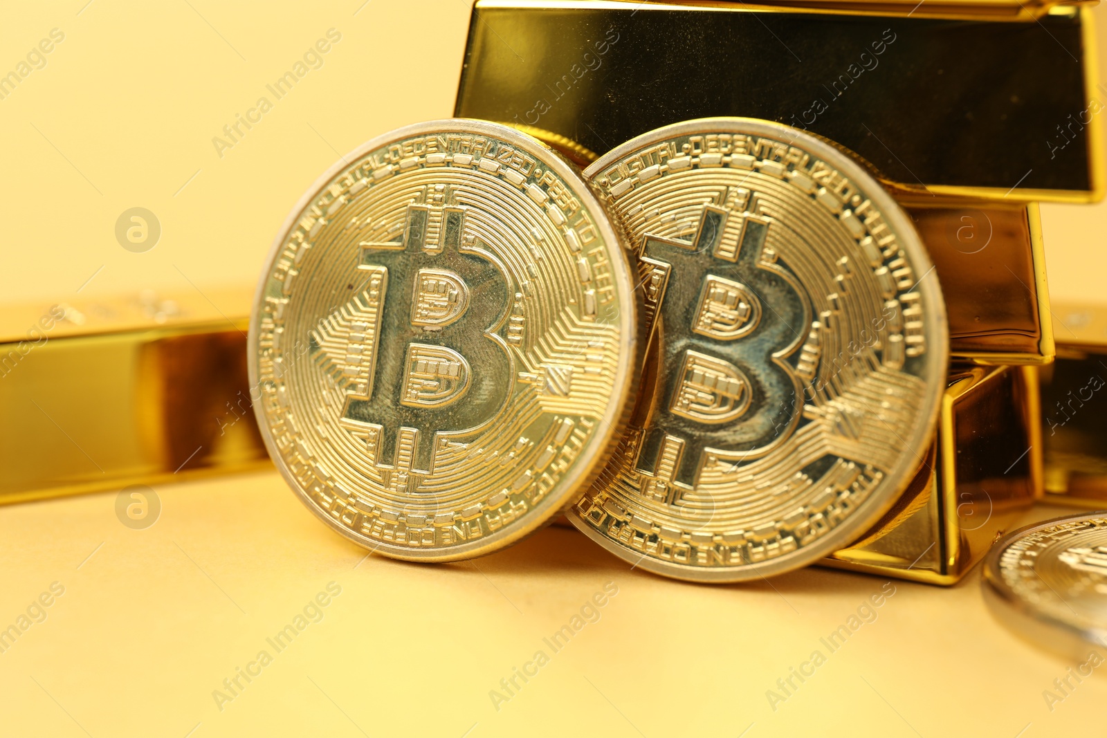 Photo of Gold bars and coins on golden background, closeup